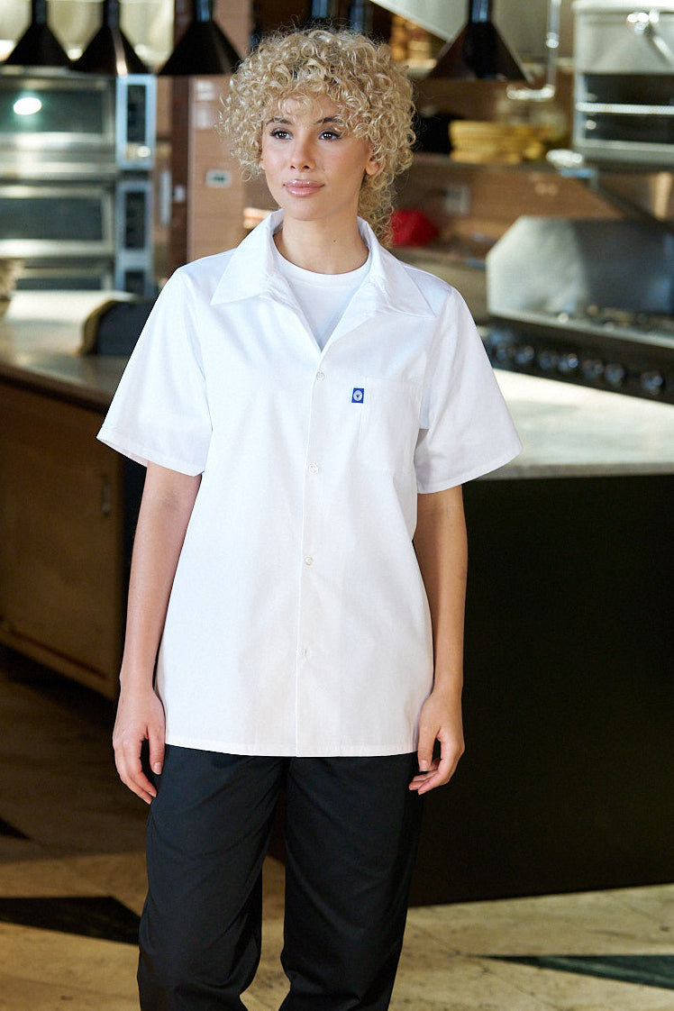 Person wearing a white shirt and black pants in a kitchen setting