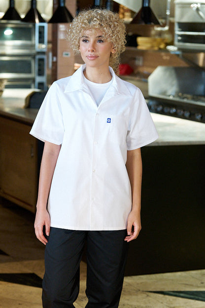 Person wearing a white shirt and black pants in a kitchen setting